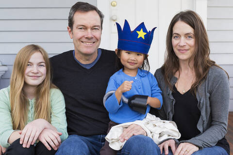 Familie lächelnd zusammen vor dem Haus, lizenzfreies Stockfoto
