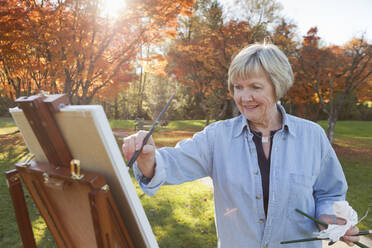 Ältere Frau malt im Freien - BLEF06708