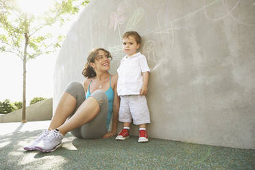 Mixed race mother sitting with son outdoors - BLEF06734