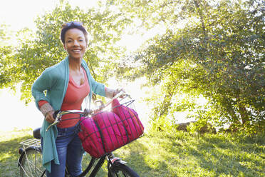 Black woman pushing bicycle outdoors - BLEF06751