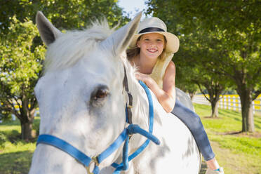 Kaukasisches Mädchen reitet Pferd auf unbefestigtem Weg - BLEF06761
