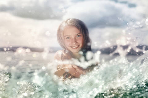Caucasian girl splashing in lake stock photo
