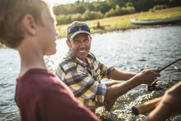 Caucasian father and son fishing in river - BLEF06885