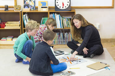 Montessori-Lehrer hilft Schülern im Klassenzimmer - BLEF06957