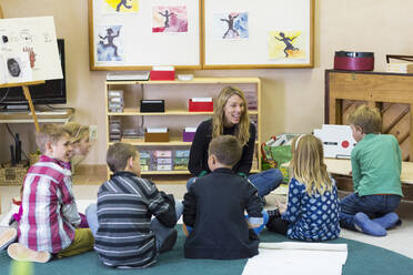 Montessori-Lehrer im Gespräch mit Schülern im Klassenzimmer - BLEF06960