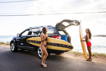 Surfer entladen Surfbretter aus einem Auto in Strandnähe - BLEF06991