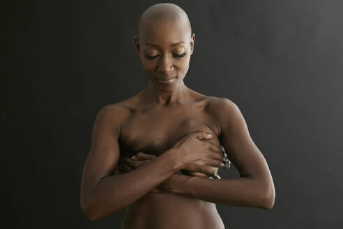 Nude African American cancer survivor covering her breasts - BLEF07018