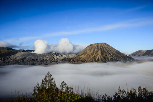 Hohe Winkelansicht von Wolken unter rauchenden Vulkanen - MINF12338