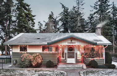 Verschneites Haus mit Weihnachtsbeleuchtung - MINF12372