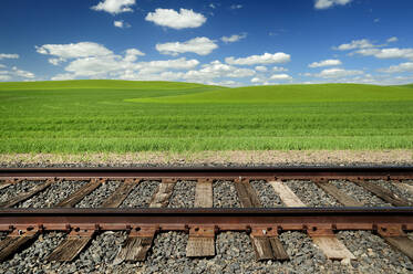 Eisenbahnschienen und sanfte Hügel in ländlicher Landschaft - MINF12380