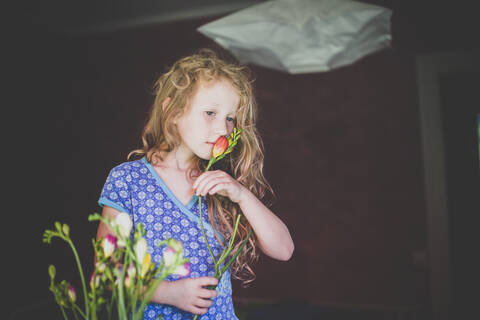 Mädchen riecht an einer Blume, lizenzfreies Stockfoto