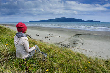 Frau beim Ausruhen am Strand von Foxton, Kapiti Coast, Nordinsel, Neuseeland - RUNF02687