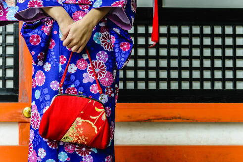 Close up of woman in kimono holding purse - MINF12432