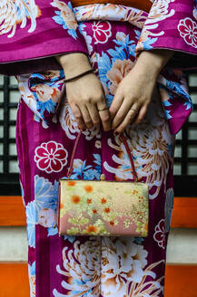 Close up of woman in kimono holding purse - MINF12433