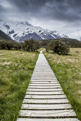 Wooden boardwalk toward mountain range - MINF12493