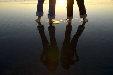 Reflection of legs in water at beach - MINF12497