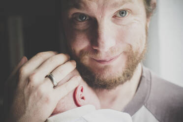 Porträt eines Vaters, der seinen eine Woche alten Sohn im Arm hält - IHF00121