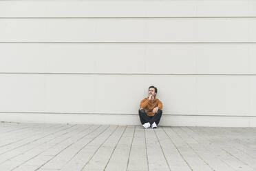 Young man sitting on ground, thinking - UUF17882