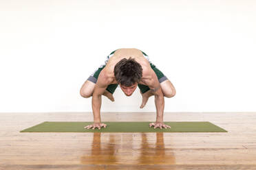 Man practicing yoga in studio - MINF12582