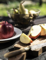 Aufgeschnittener Apfel auf dem Tisch im Freien - MINF12612