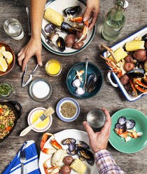 High angle view of hands at seafood dinner - MINF12616