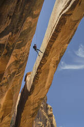 Rock climber hanging on rope on arch - MINF12629