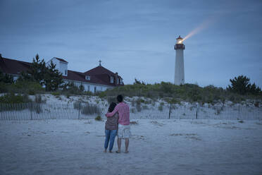 Asiatisches Paar beobachtet Leuchtturm am Strand - MINF12633