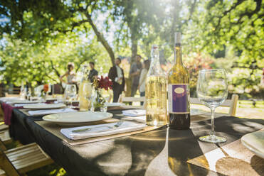 Wine bottles on table at party outdoors - MINF12649