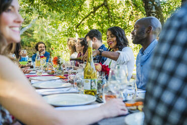 Freunde genießen den Wein bei einer Party im Freien - MINF12651