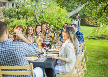 Freunde genießen den Wein bei einer Party im Freien - MINF12654