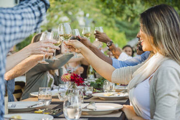 Friends toasting with wine at party outdoors - MINF12655