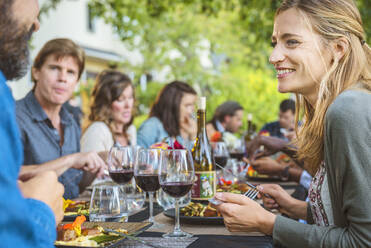 Freunde genießen den Wein bei einer Party im Freien - MINF12657