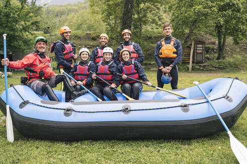 Ausbilder und eine Gruppe von Freunden bei einem Rafting-Kurs posieren im Boot - FBAF00718
