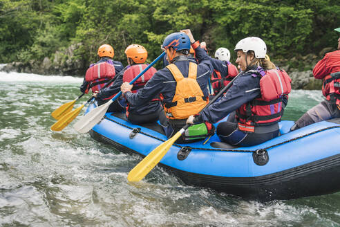 Gruppe von Menschen beim Rafting im Schlauchboot auf einem Fluss - FBAF00738