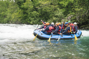 Group of people rafting in rubber dinghy on a river - FBAF00739