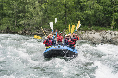 Group of people rafting in rubber dinghy on a river - FBAF00740