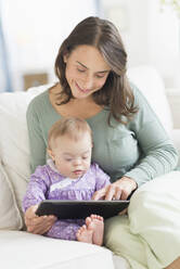 Caucasian mother reading to baby with Down Syndrome - BLEF07036