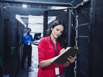 Business people working in server room - BLEF07144