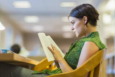 Gemischtrassiger Student studiert in der Bibliothek - BLEF07172