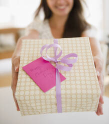 Indian woman holding out Mother's Day gift - BLEF07191