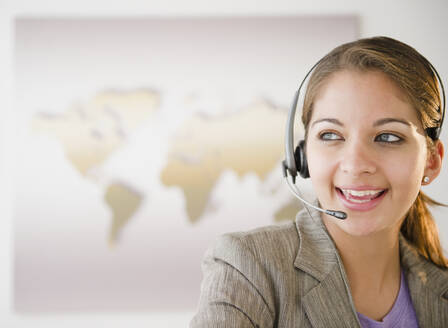 Indische Geschäftsfrau spricht mit Headset im Büro - BLEF07194