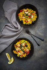 Paella mit Reis, Paprika, Tomaten, Artischocken, Erbsen, schwarzen Oliven, Curcuma und Garnelen - LVF08095