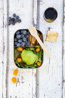 Lunchbox mit Salat, Avocado und gelber Tomate, Cracker, Blaubeeren und Salatdressing, von oben - LVF08099