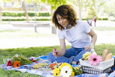 Relaxed woman having a picnic in park - FMOF00688