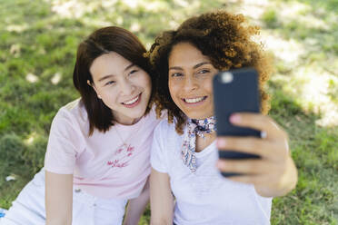 Zwei glückliche Frauen machen ein Selfie im Park - FMOF00709
