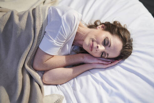 Zufriedene Frau schläft im Bett - PNEF01657