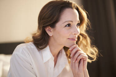 Portrait of smiling woman in bedroom at home - PNEF01676