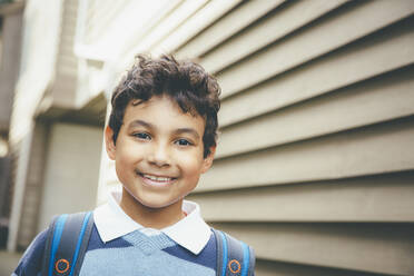 Mixed race boy smiling near house - BLEF07206