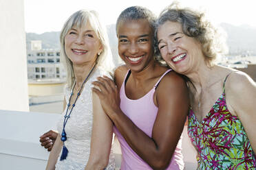 Gemeinsam lächelnde Frauen auf einem städtischen Dach - BLEF07239