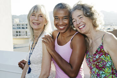 Women smiling together on urban rooftop - BLEF07239